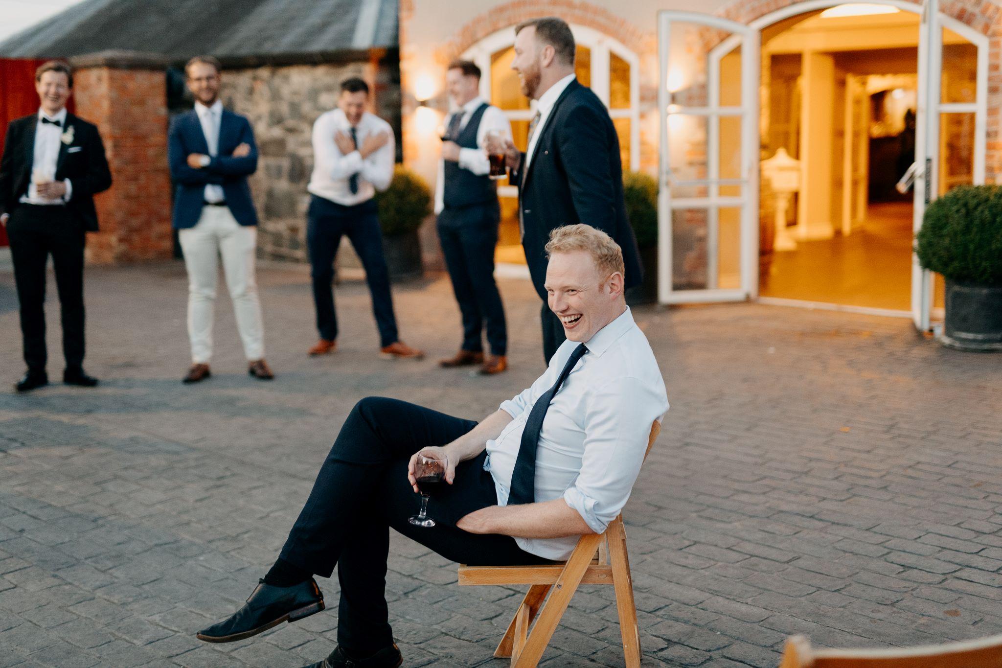 Best Man Enjoying a glass of Red wine in the courtyard at Larchfield Estate Co Down Best Wedding Venue Northern Ireland