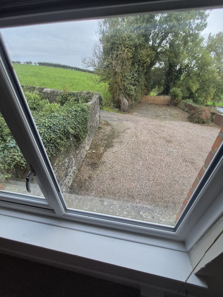 View from Master Bedroom Front over parking area. Garden view from other side of room.